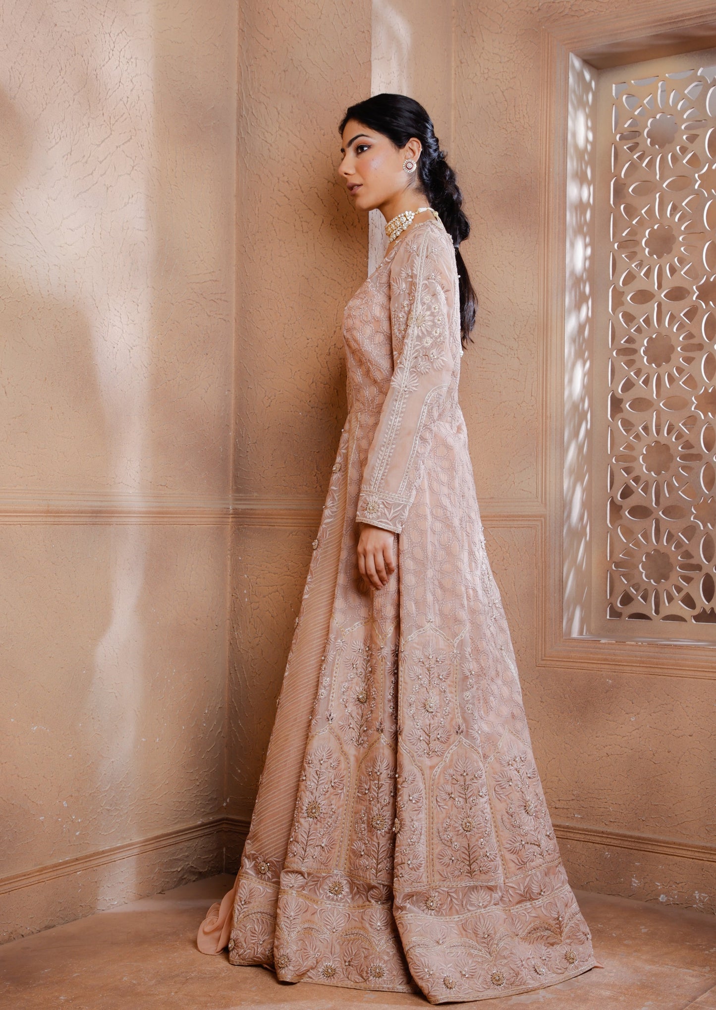 The intricately embroidered long Jacket shimmers with tonal threads, applique & hand embroidery adding a touch of opulence. Paired with a raw silk blouse and georgette lehenga.