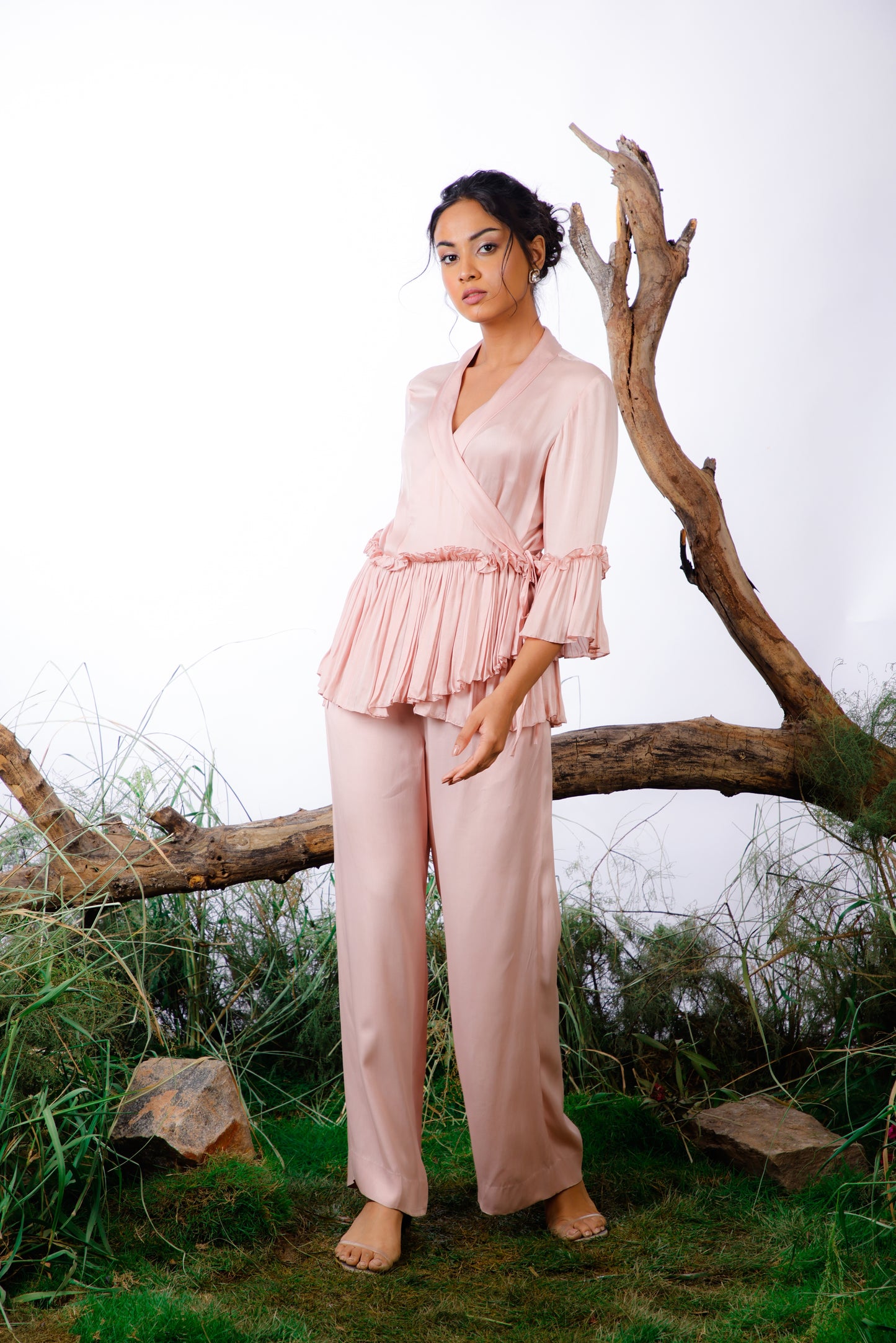 This Coord Set consists of a pleated ruffle top with side ties and straight-cut trousers with pockets.