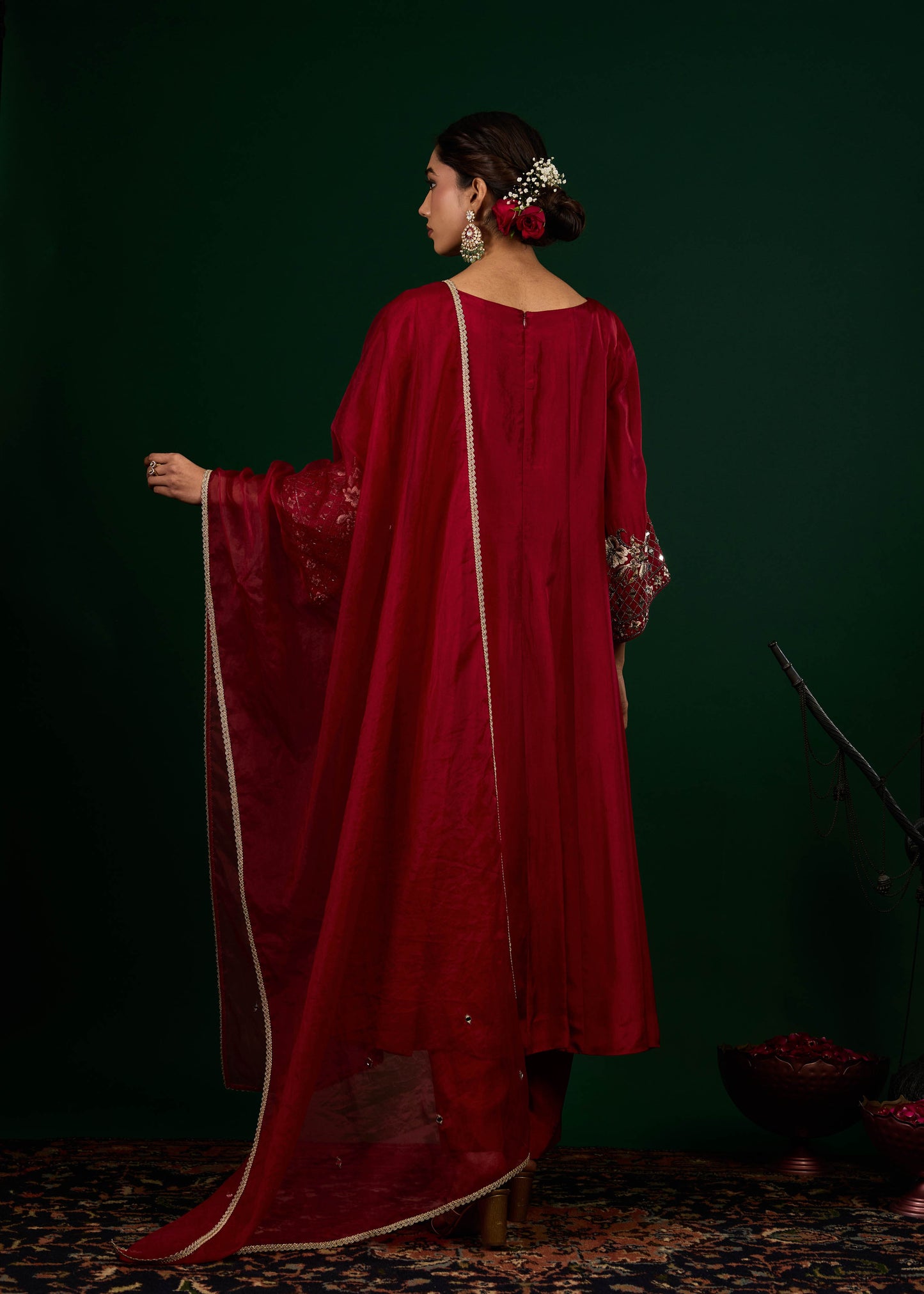 Woman in a red traditional outfit with a dark green background