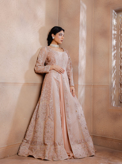 The intricately embroidered long Jacket shimmers with tonal threads, applique & hand embroidery adding a touch of opulence. Paired with a raw silk blouse and georgette lehenga.