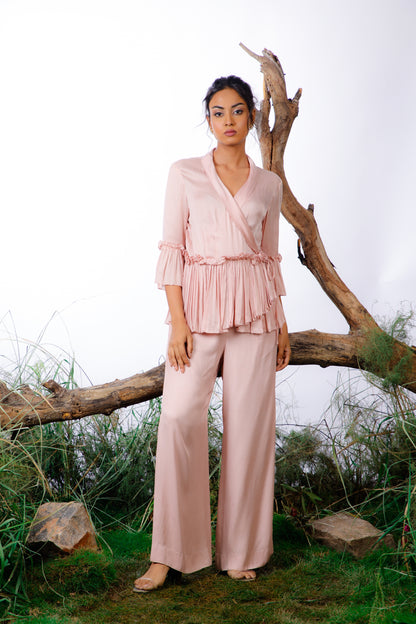 This Coord Set consists of a pleated ruffle top with side ties and straight-cut trousers with pockets.