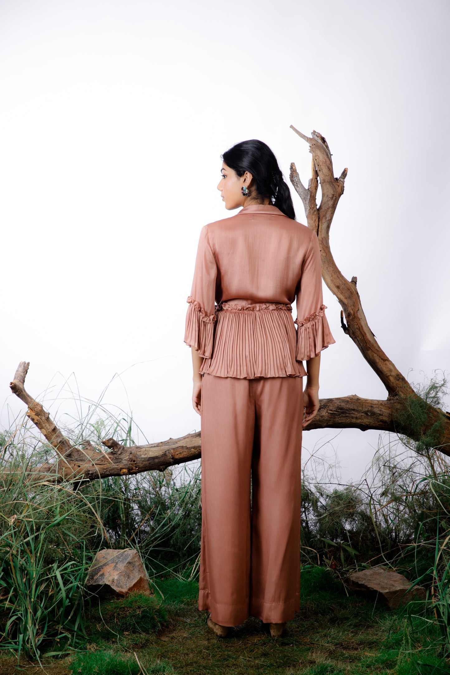 This Coord Set consists of a pleated ruffle top with side ties and straight-cut trousers with pockets.