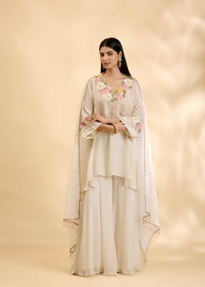 Woman wearing a floral outfit with a beige background