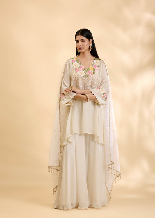 Woman wearing a floral outfit with a beige background